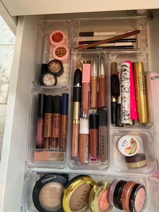 user showing a well-organized makeup drawer with clear bins