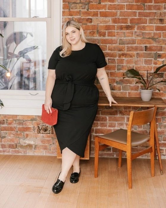 A model is seen wearing a black dress paired with black shoes.