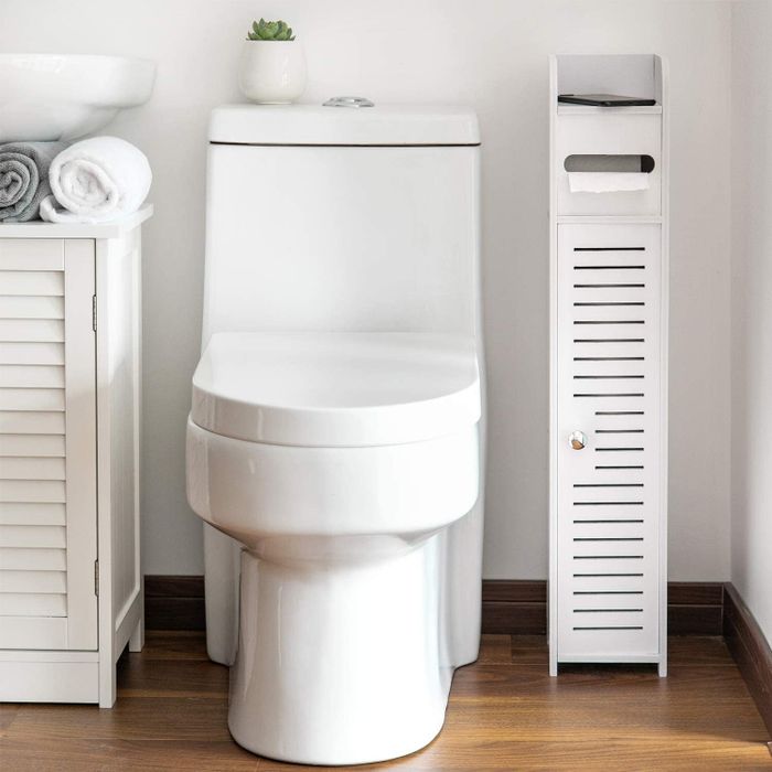 The floor cabinet tucked into the tight corner between the toilet and the wall.