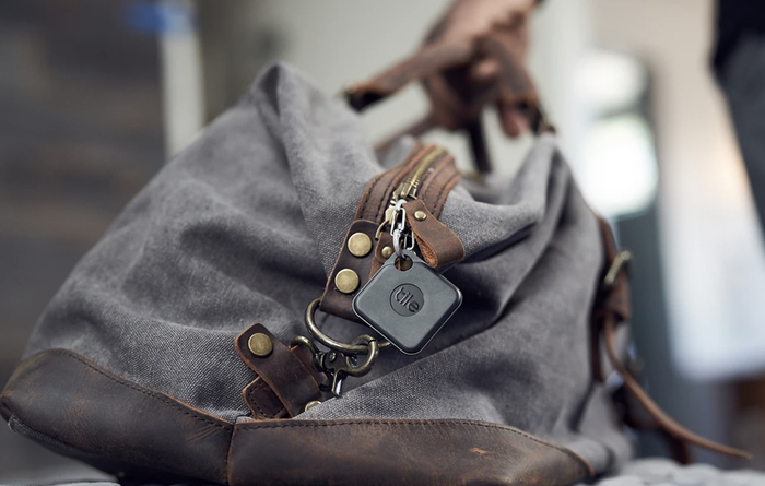 A Tile attached to the zipper of a bag, ready to help keep track of it.