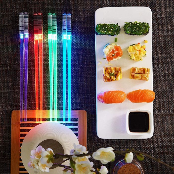 Four glowing chopsticks resting on a table, resembling Light Sabers from the iconic 