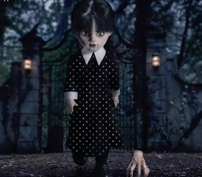 Doll of the character dressed in black with a white collar, standing beside a gate. Accompanied by a floating hand