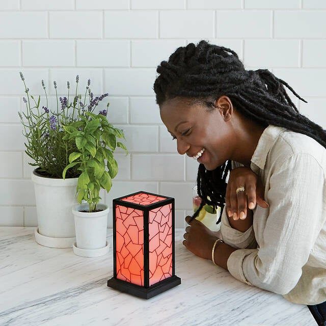 A person smiling with joy as the lamp activates and lights up.