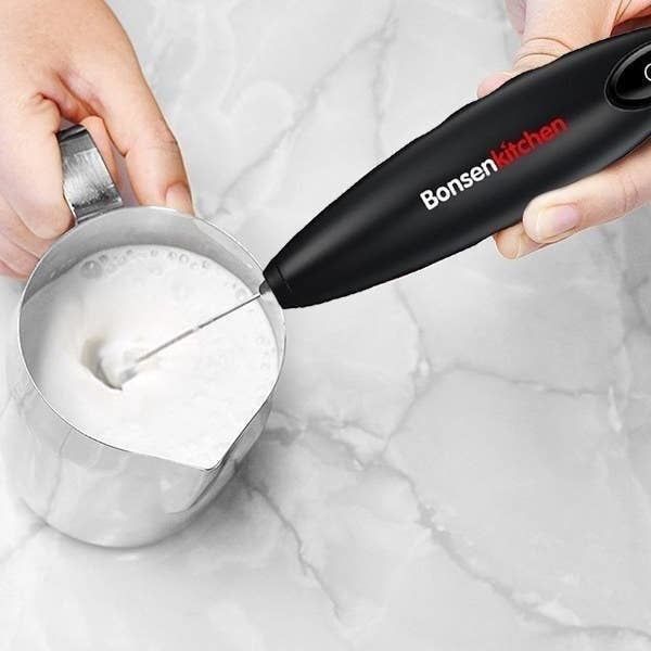 The frother is being used to whip cream to perfection, adding a creamy touch to any drink.