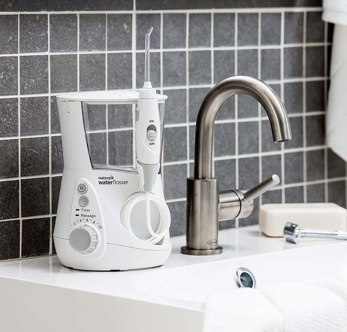 A Waterpik water flosser placed conveniently on the sink counter, ready for use to keep your smile sparkling.