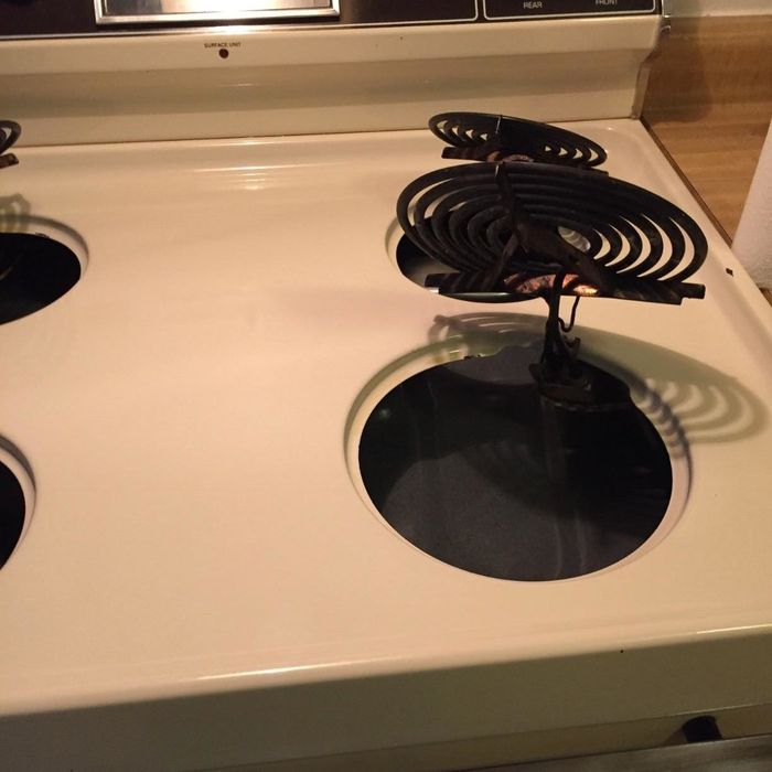 A reviewer’s photo showing their stovetop after using the drill brush, now completely spotless and looking like new