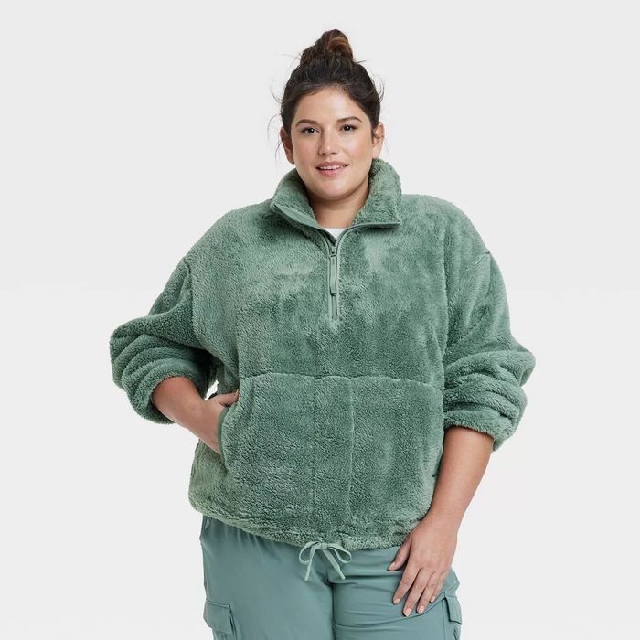 A person is wearing a green half-zip fleece pullover.