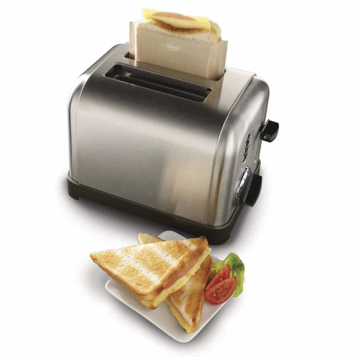 A grilled cheese sandwich alongside a toaster with another sandwich in the bag