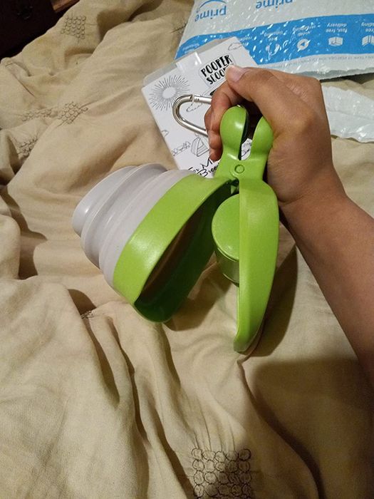 A reviewer demonstrating how to open the DogBuddy pooper scooper.