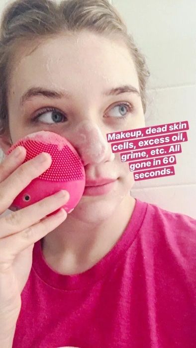 Me using the Luna Mini 2 on my face with cleanser applied, accompanied by the text