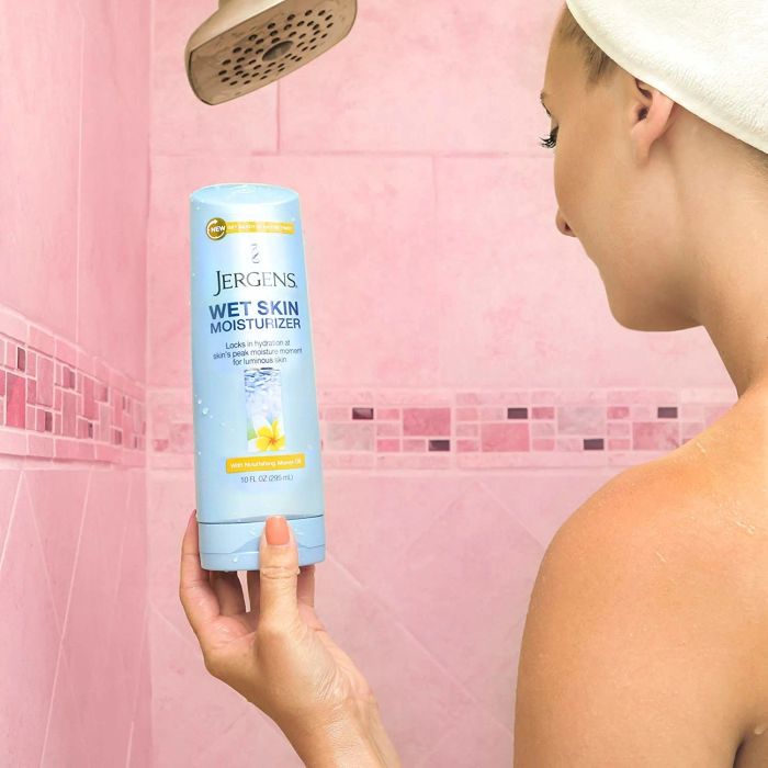 A model showcasing the lotion bottle while in the shower