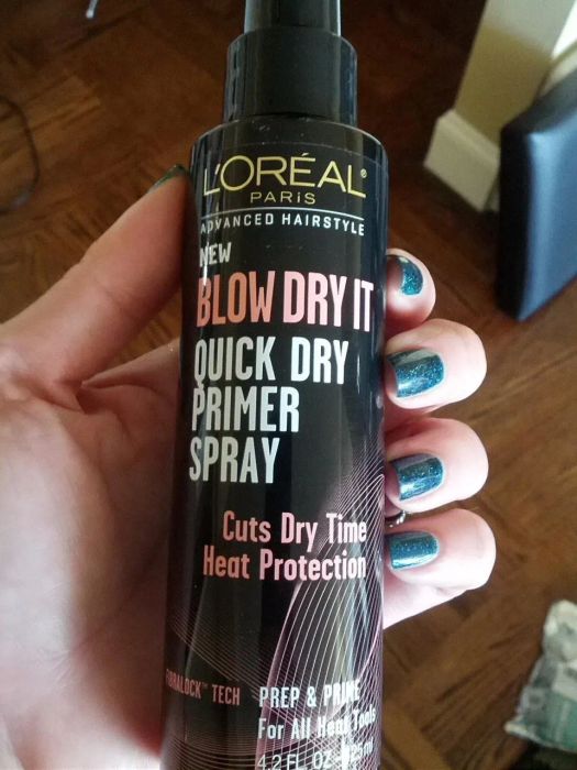 A reviewer showcasing the spray bottle in hand