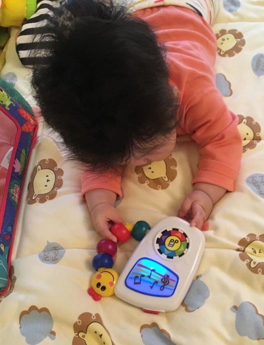 A reviewer's photo of their baby holding the toy