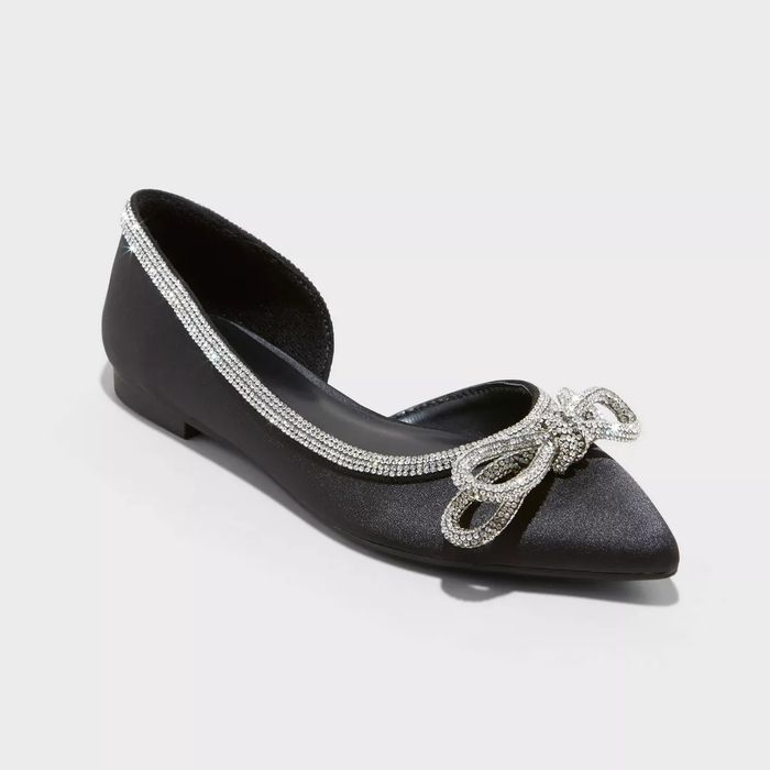 A pair of black ballet flats adorned with a silver sparkling bow