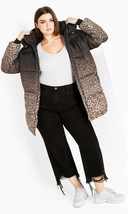 A person wearing a puffer coat without a hood, which is black at the neckline and gradually transitions into a leopard print pattern on the body of the coat.