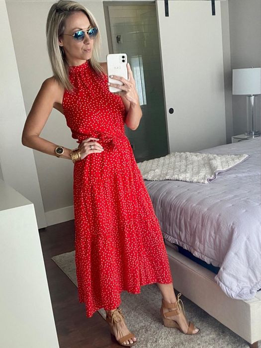 A reviewer showcasing a red, long halter dress.