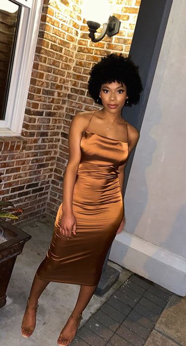 A reviewer wearing the dress in a rich brown color.