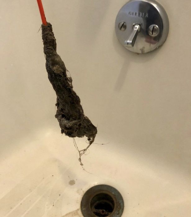 A reviewer demonstrating the amount of hair they pulled out using the FlexiSnake