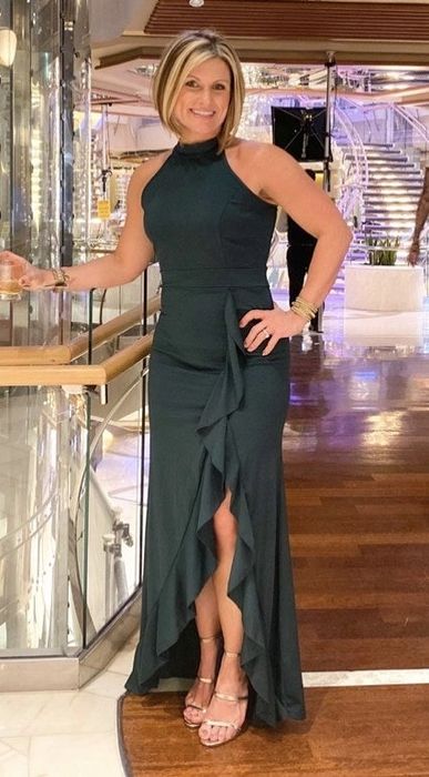 A reviewer wearing an elegant green floor-length gown