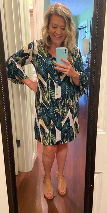 A reviewer rocking a knee-length palm print dress.