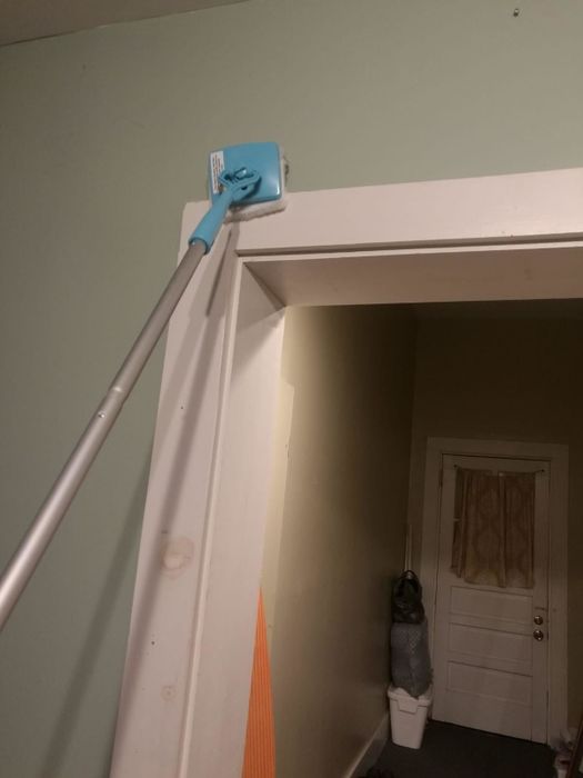 An Amazon reviewer showing the Baseboard Buddy extended to reach the top of a door frame