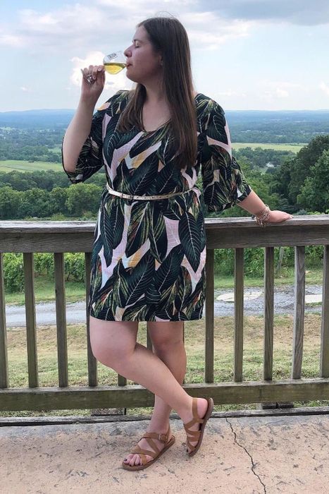 A reviewer sporting a knee-length floral dress.