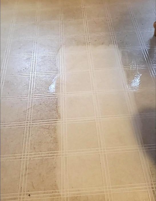 A tile floor being cleaned by a reviewer using the magic eraser.