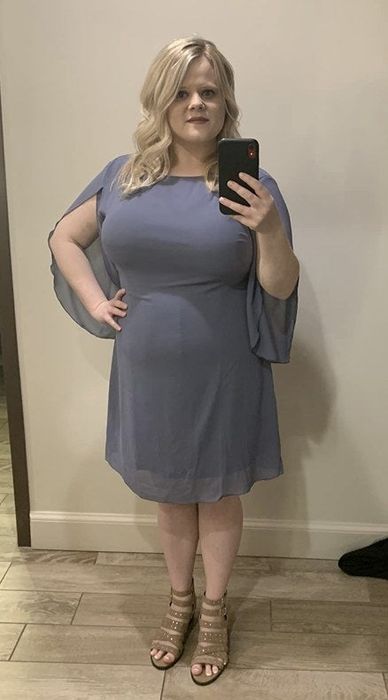 A reviewer models a grey chiffon dress.