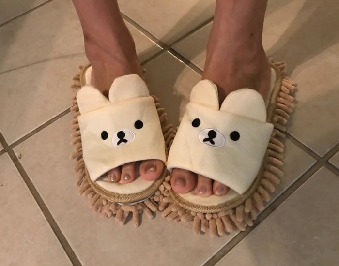 A reviewer wearing the bear-shaped mop slippers