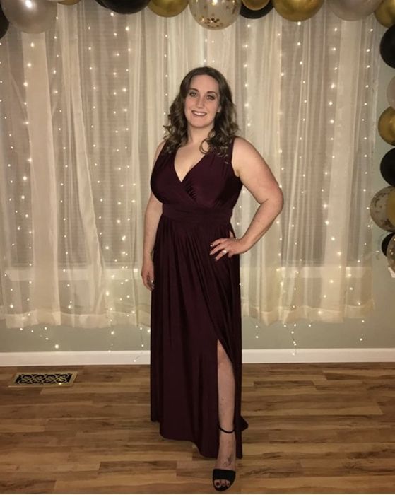 A reviewer showcases a maroon, floor-length gown.
