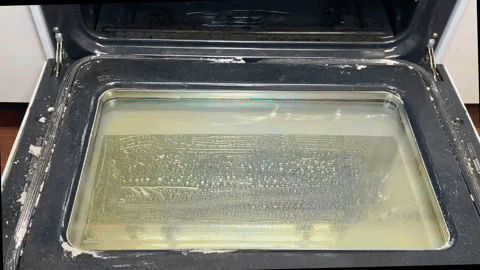 GIF showing a person wiping oven cleaner with a towel