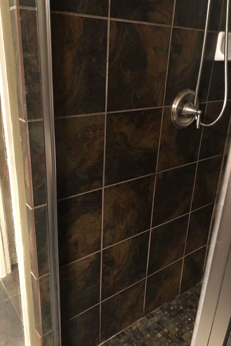 The same reviewer proudly showing their shower, fully restored after using the product
