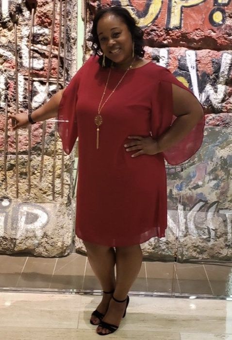 A reviewer shows off a red chiffon dress.