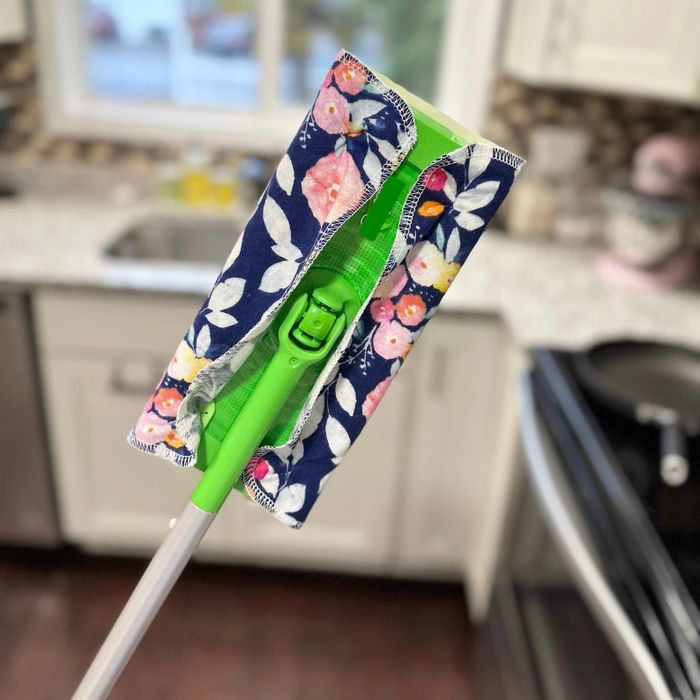 A floral-patterned mop pad placed on a Swiffer