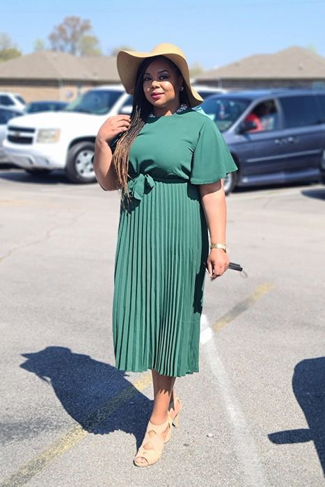 A reviewer donning an elegant long green dress.