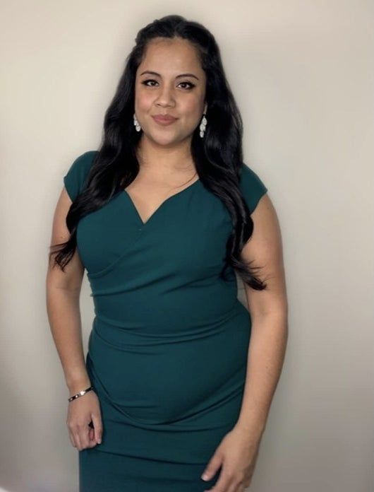 A reviewer showcasing a stunning green bodycon dress