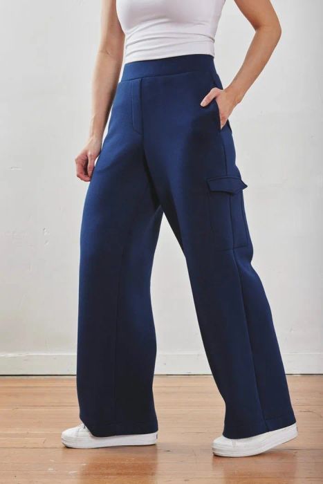 A model donning the blue version of the pants, complemented by crisp white sneakers.