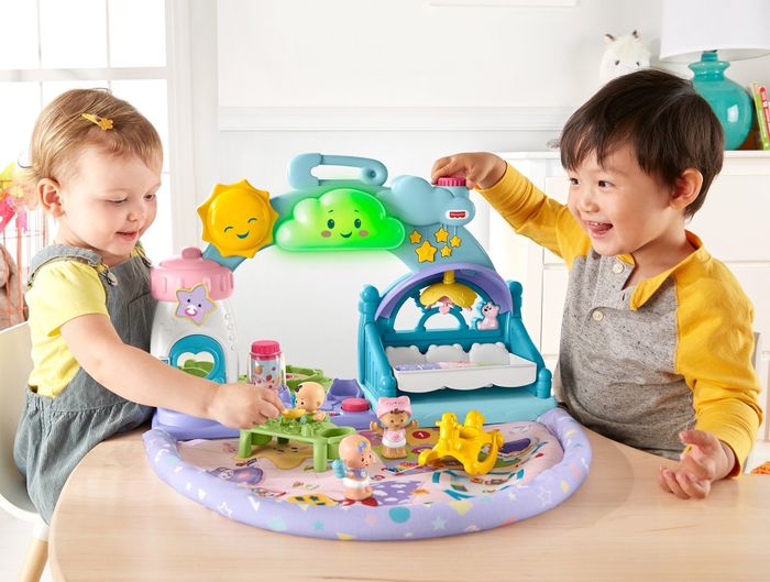 Children interacting with a plastic playset featuring a soft bottom mat and fun, interactive attachments.