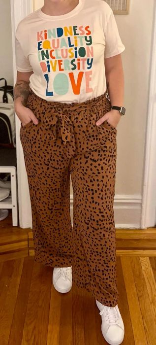 a reviewer modeling the pants with a brown and black leopard print