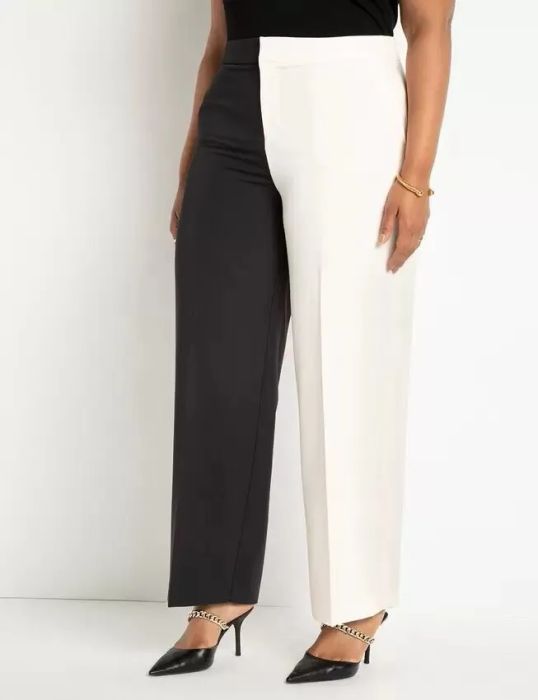 A model is pictured wearing the pants, featuring one black leg and one white leg, creating a striking contrast.
