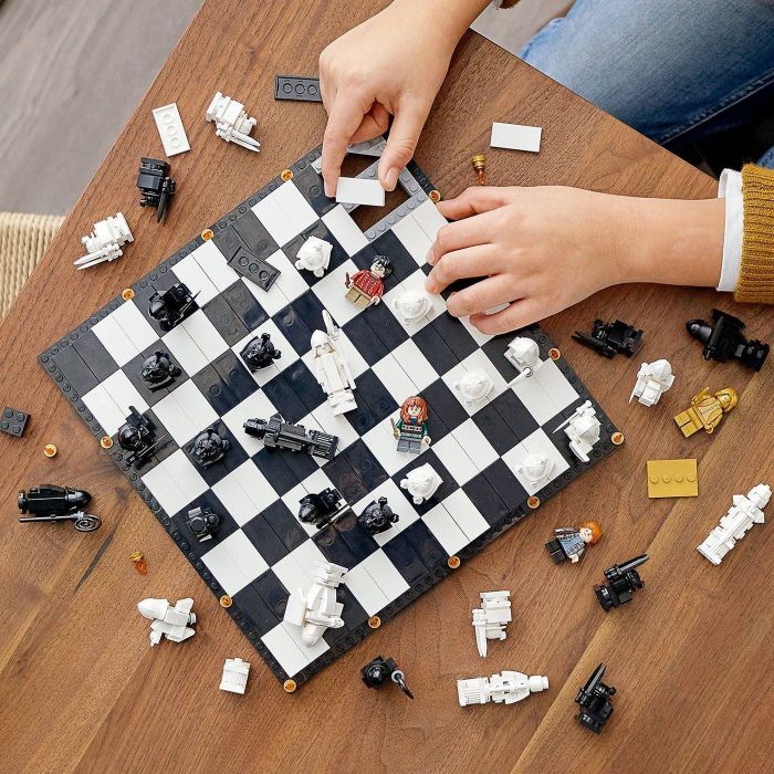 Hands holding a Harry Potter-themed chess set