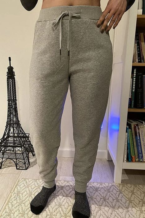 a reviewer modeling the light gray sweatpants