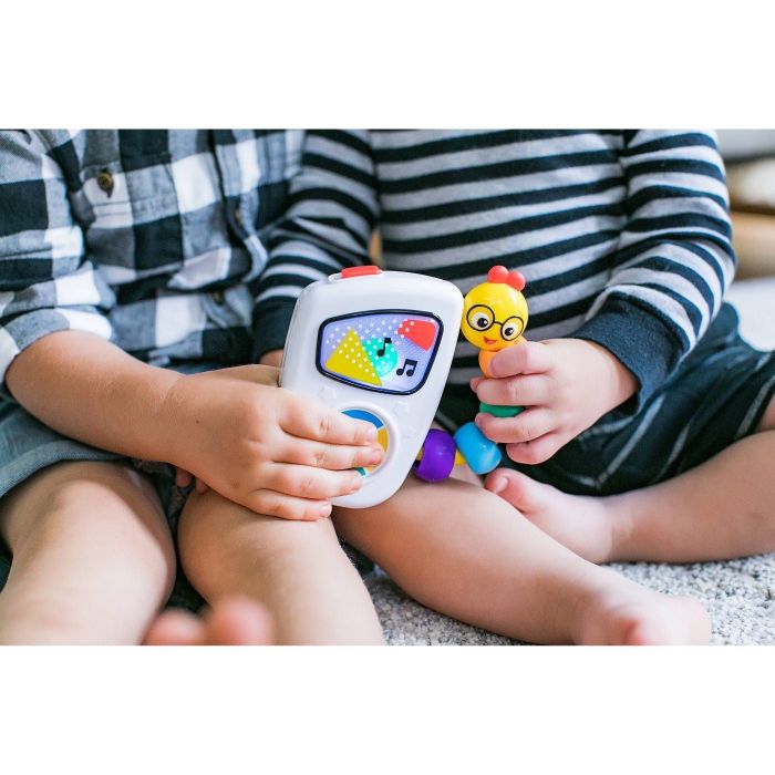 Two infants enjoying the Baby Einstein Take Along Tunes toy