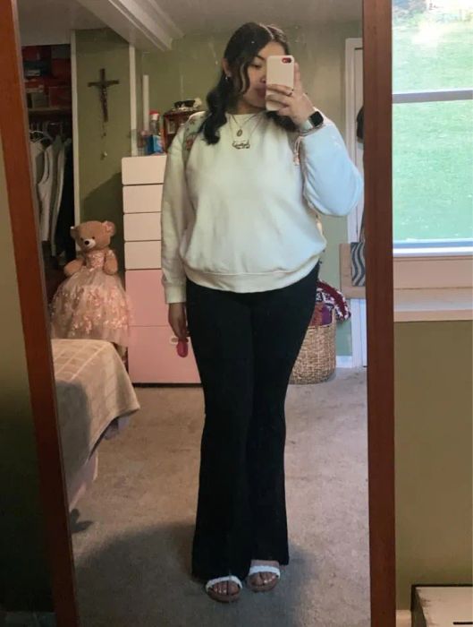 a reviewer modeling the black version of these chic pants