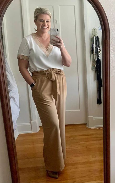 a reviewer showcasing the pants in a solid tan shade