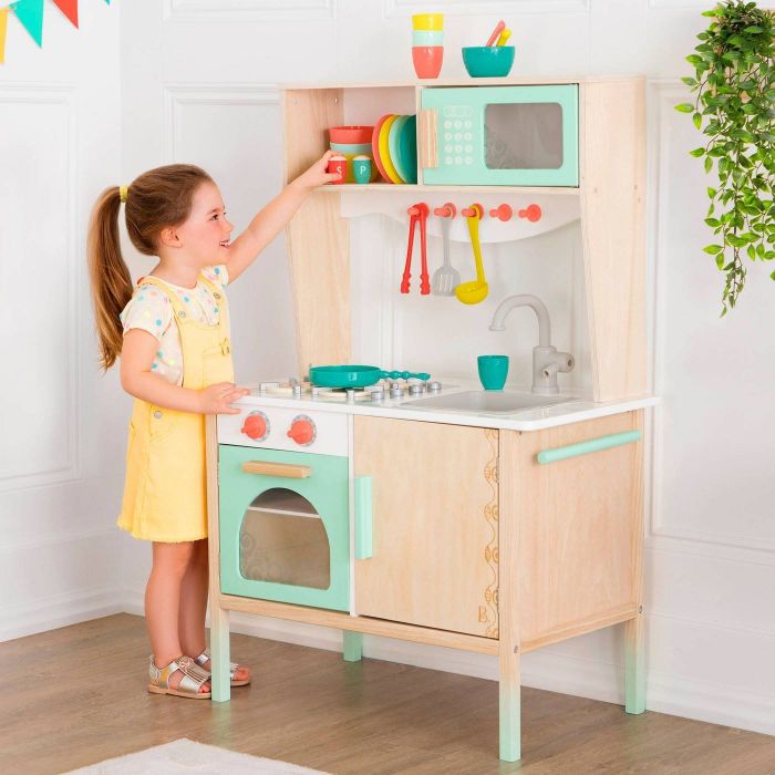 A child enjoying playtime with a wooden kitchen set.