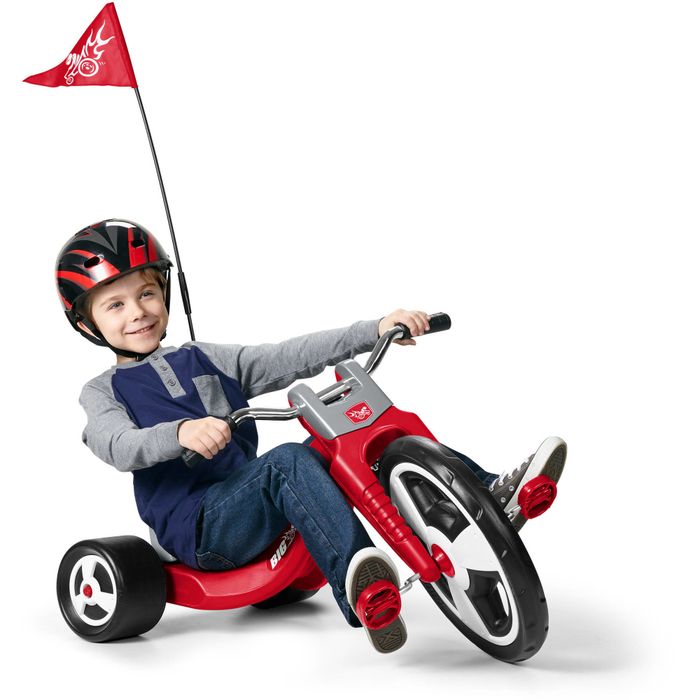 A red, low-profile tricycle with a racing flag attached, ready for fun.