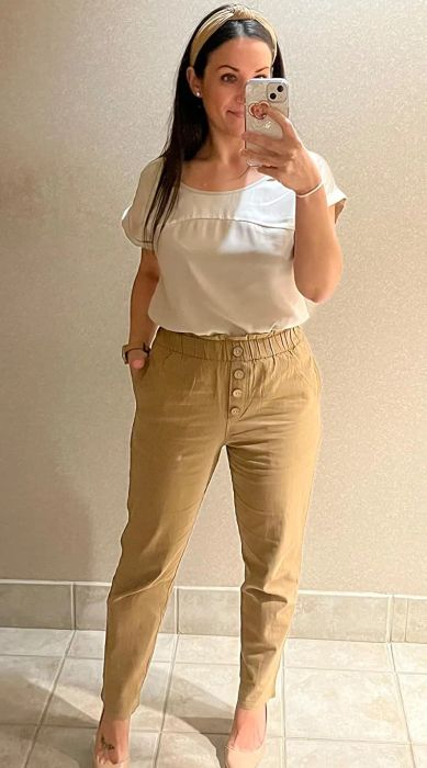 A reviewer showcasing khaki-colored pants, exuding a casual yet refined vibe.