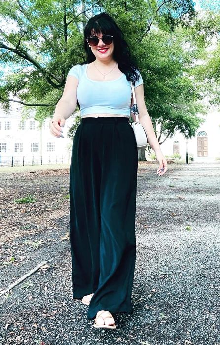 A reviewer showcasing the same pants, but this time in a sleek black shade.