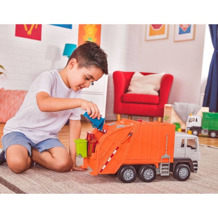 Child playing with an orange trash truck toy.